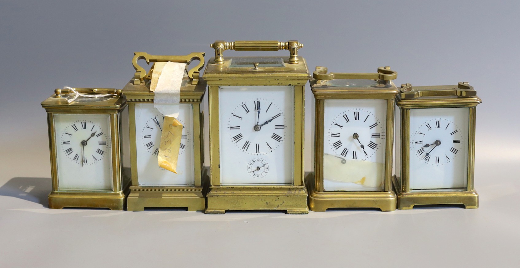 Five early 20th century and later lacquered brass carriage clocks and timepieces, in varying states of repair